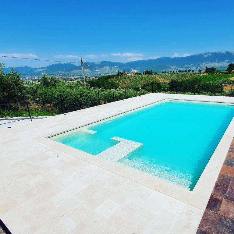Piscina con vista su colline e cielo azzurro.